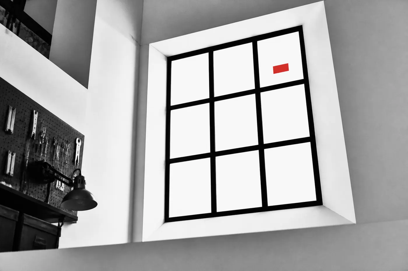 Twelve-pane window motif in paper, ink, and signal red, oblique editorial view.